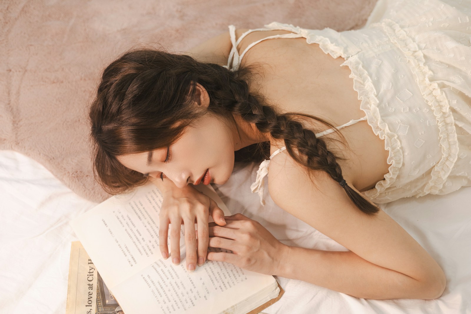 a woman laying on a bed reading a book